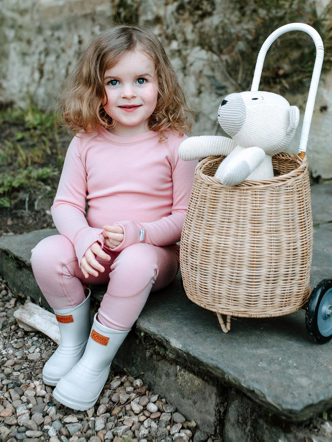 Merino wool kids thermal baselayer pyjama in pink sitting #colour_vintage-rose