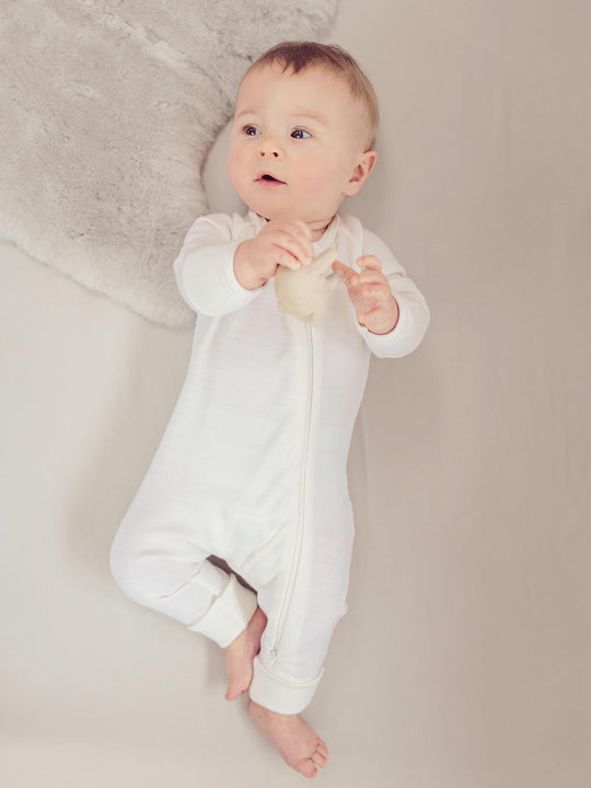 merino baby sleepsuit white front #colour_pure-ivory