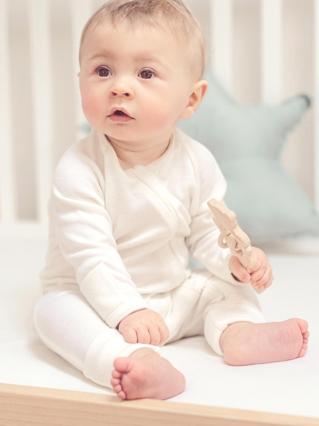 merino baby sleepsuit white side #colour_pure-ivory