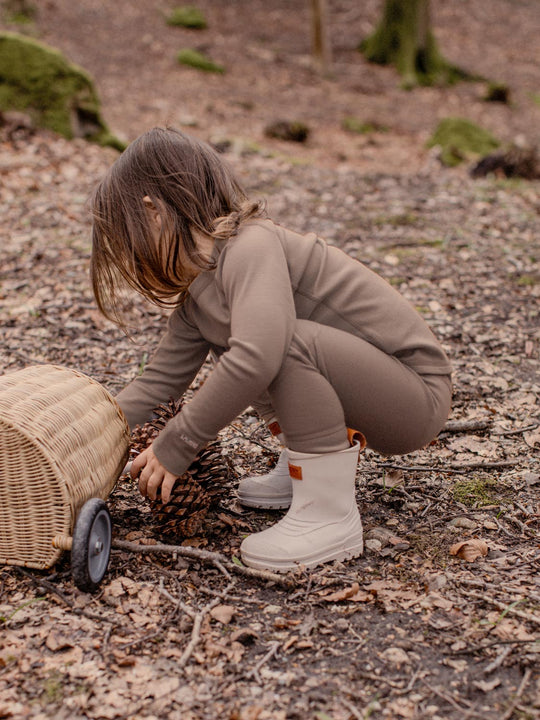 Merino wool kids thermal baselayer pyjama in neutral beige action #colour_pebble